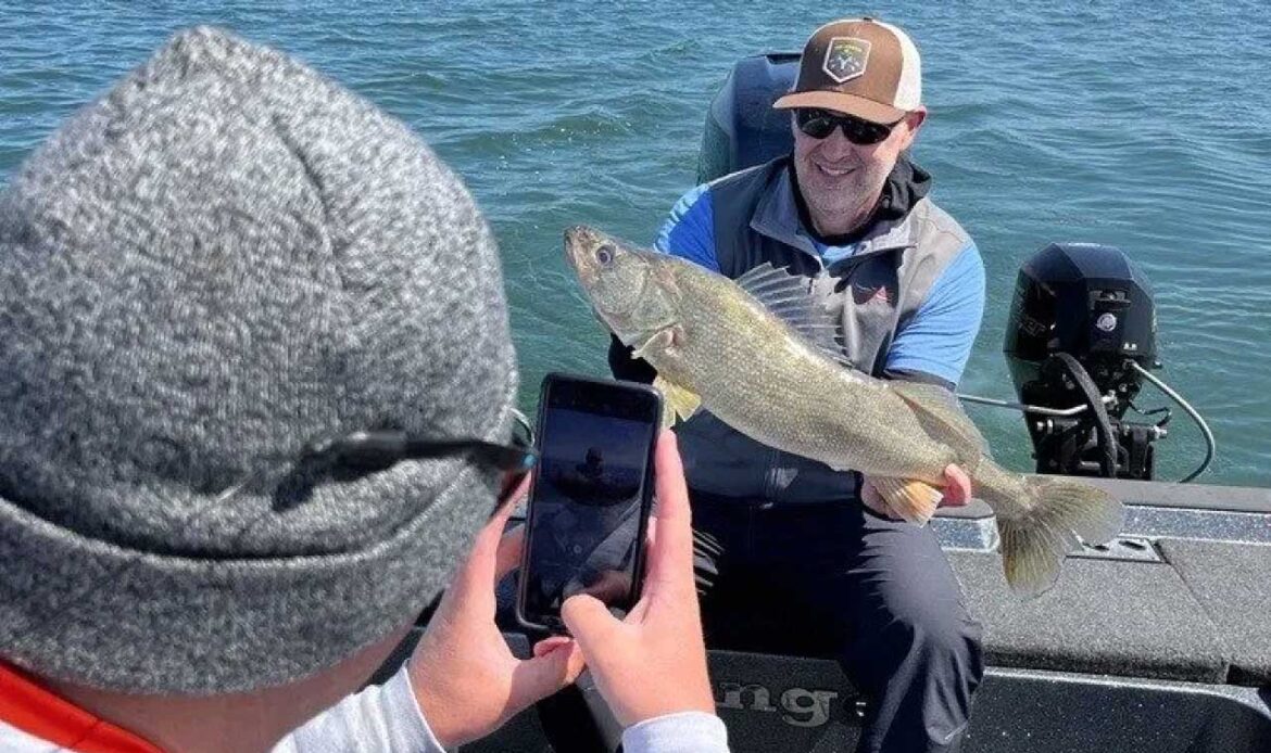 Friends take a photo of a laker Erie walleye from tournament boat